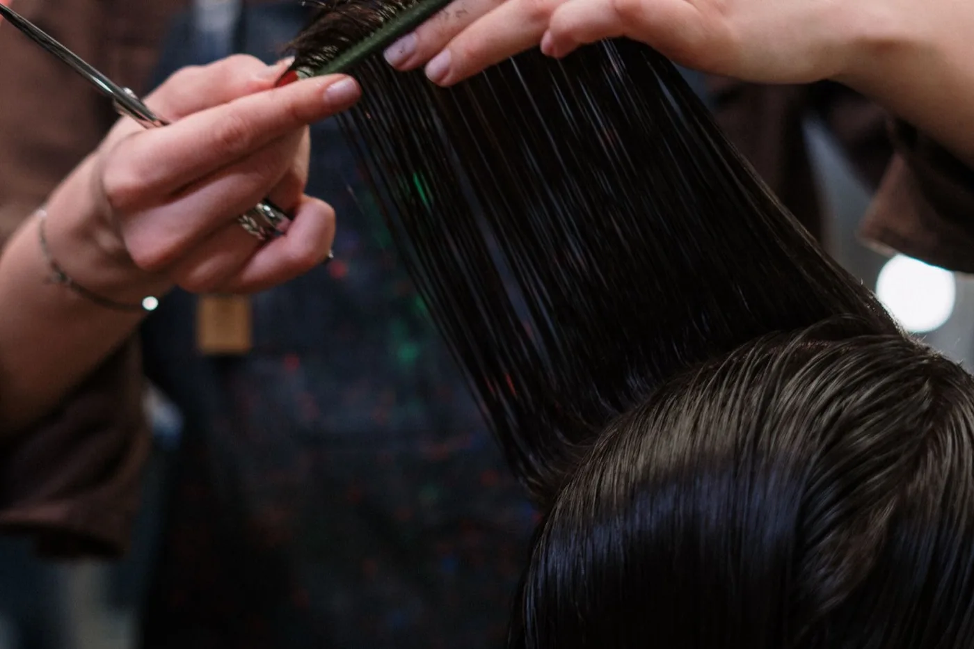 Coiffeuse coupant des cheveux mi-longs aux ciseaux et au peigne