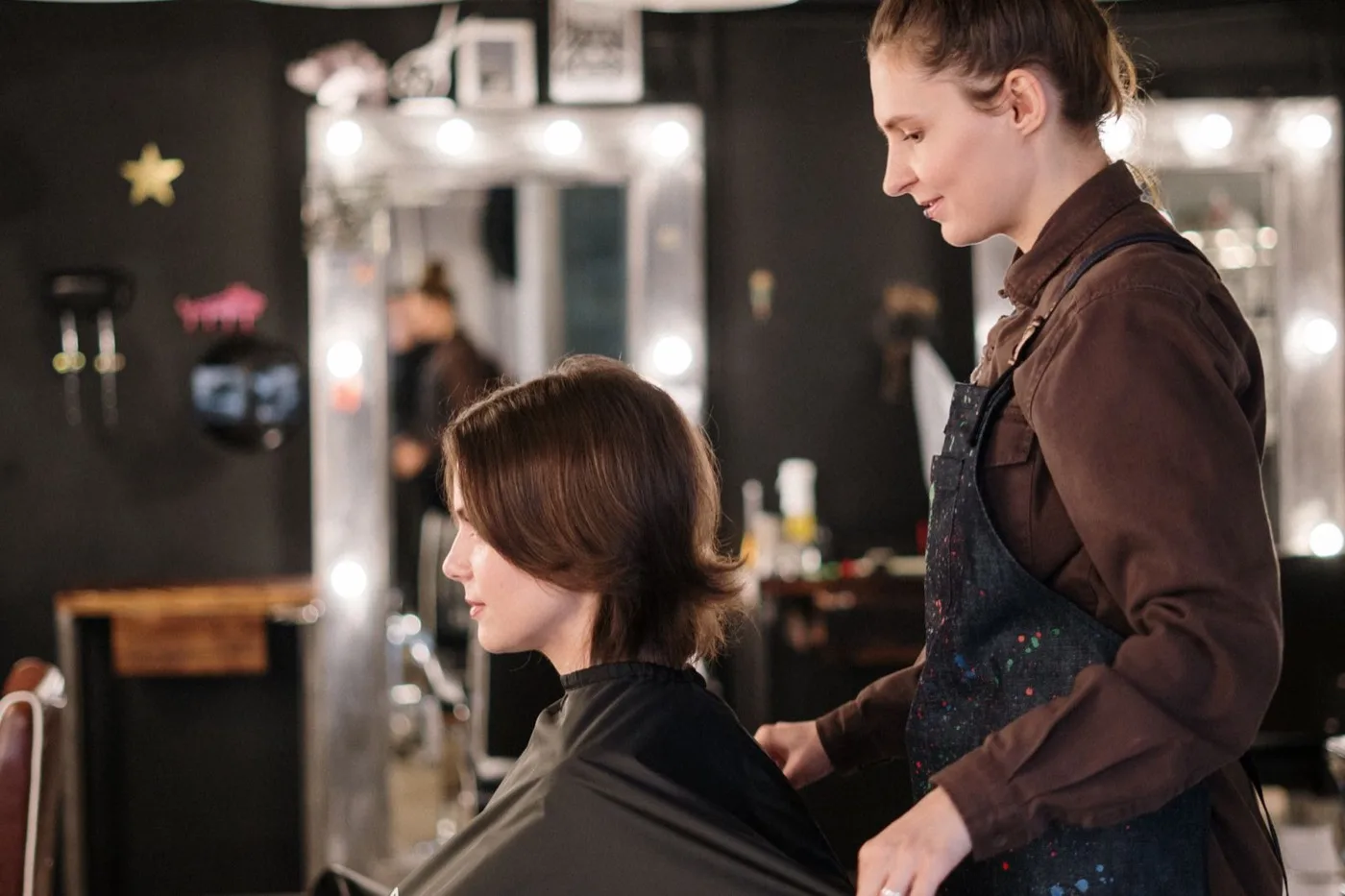 Vanessa, coiffeuse, au travail au miroir du salon